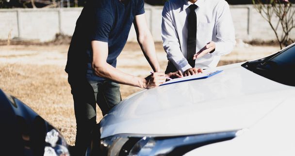 Clients et agents d'assurance automobile ont conclu des accords et signé des documents pour réclamer une indemnisation après un accident de voiture, concept d'assurance
. - Photo, image