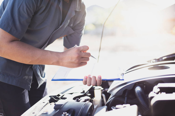 Auto reparatie specialist heeft de motor reparatie lijst gecontroleerd voor zowel interne als externe systemen, Auto reparatie service concept. - Foto, afbeelding