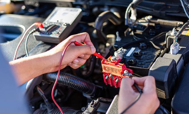 Il tecnico di riparazione auto ha ispezionato lo stato del motore utilizzando l'amperometro, concetto di servizio di riparazione auto
. - Foto, immagini