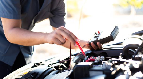 Il tecnico di riparazione auto ha ispezionato lo stato del motore utilizzando l'amperometro, concetto di servizio di riparazione auto
. - Foto, immagini