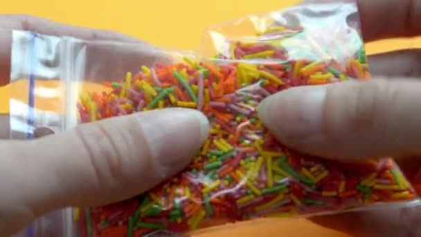 Elégedettségi videó. Női ujjak érzik táska sprincle édességek és sütemények - Felvétel, videó