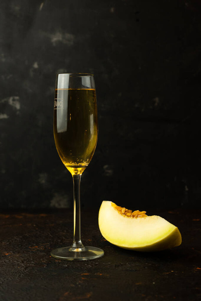 jugoso melón amarillo con una copa de champán
 - Foto, Imagen