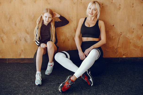 Mother and daughter doing yoga in a yoga studio - Фото, изображение