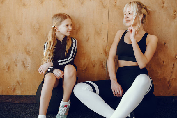 Mother and daughter doing yoga in a yoga studio - Фото, изображение