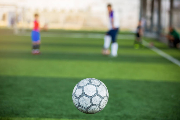 Футбольний м'яч відбивається з розмитим зеленим тлом
 - Фото, зображення