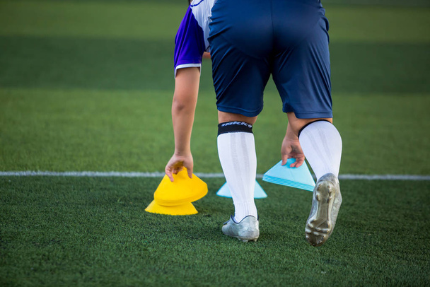 Entrenador o jugador de fútbol está poniendo los conos marcador para el fútbol tr
 - Foto, Imagen