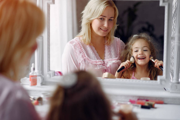 Mother and daughter gather in the morning in front of a mirror - Foto, Imagen