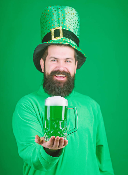 Fresh and green. Irish man with beard drinking green beer. Bearded man toasting to saint patricks day. Celebrating saint patricks day in bar. Hipster in leprechaun hat holding beer mug - Foto, Imagen