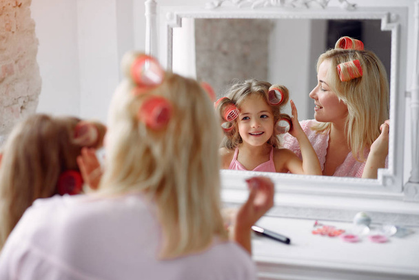 Mom and daughter at home with curlers on their heads - Foto, Imagen