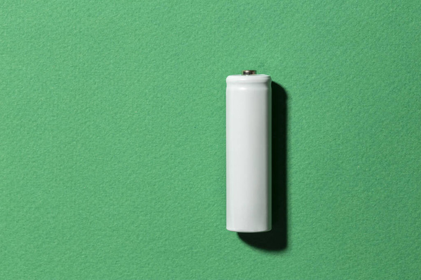 White size AA batteries on a green background top view.  - Foto, Imagem
