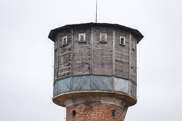 alter gemauerter Wasserturm mit Holzdach, in kleiner Landschaft gelegen - Foto, Bild