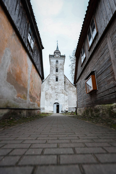 Plazma 'daki iki eski ev arasındaki güzel eski beyaz kilise. - Fotoğraf, Görsel