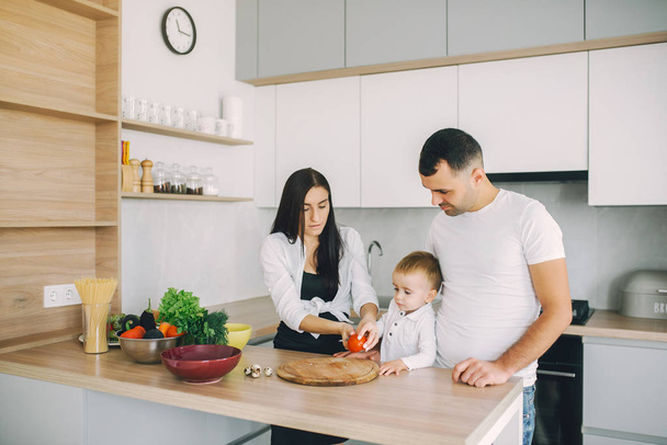 Family prepare the salad in a kitchen - Zdjęcie, obraz