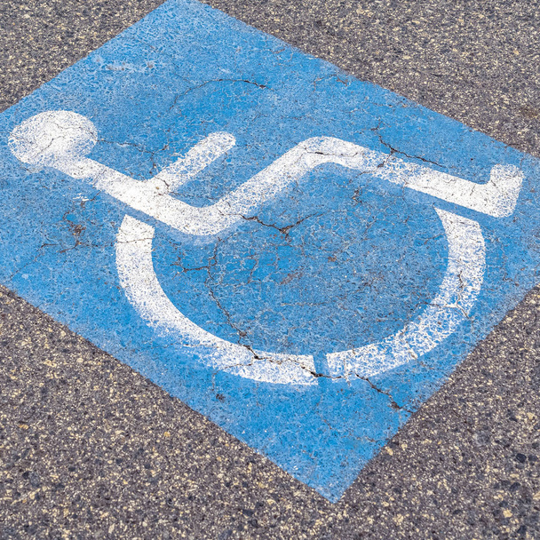Πλατεία άτομα με ειδικές ανάγκες ή ανάπηρους πινακίδα του δρόμου σε μια συννεφιασμένη ημέρα - Φωτογραφία, εικόνα