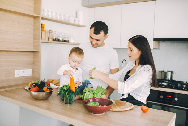 Family prepare the salad in a kitchen - Фото, изображение