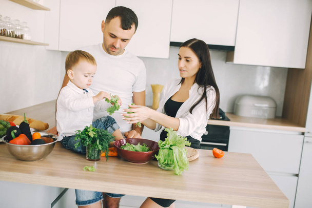 Family prepare the salad in a kitchen - Фото, изображение