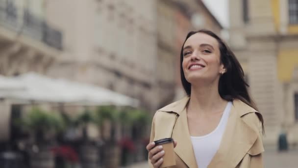 Beautiful Young Happy Girl Holding Paper Coffe Cup Drinking Cofee Smiling Walking Relaxed Looking around at City Background Close Up. - Video, Çekim