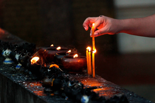 Burning candles and oil lamps in a buddhist temple in Thailand - Photo, Image