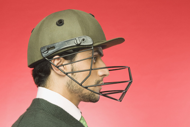 Businessman wearing a cricket helmet - Photo, image