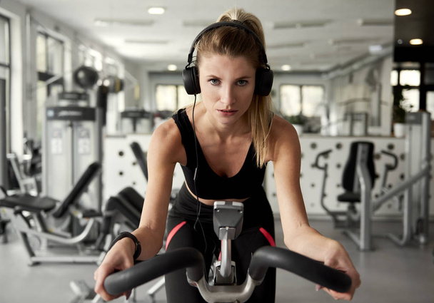 Sporty woman working out with exercise bike - Photo, Image