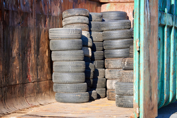 Hromádky starých ojetých automobilových pneumatik v recyklované staré černé auto gumy - Fotografie, Obrázek