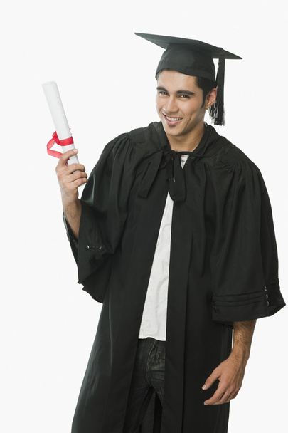 Man in a graduation gown holding a diploma - 写真・画像