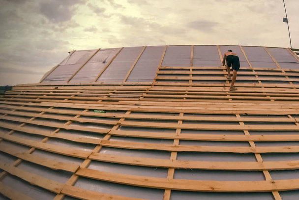 Установка крыши на доме. Рабочие делают крышу
. - Фото, изображение