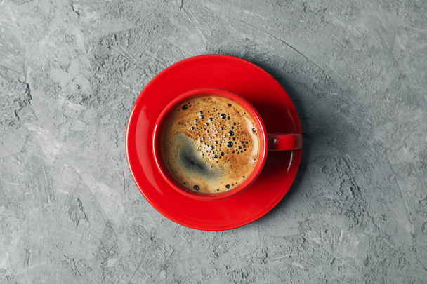 Piros csésze kávét a szürke háttér, felülnézet - Fotó, kép