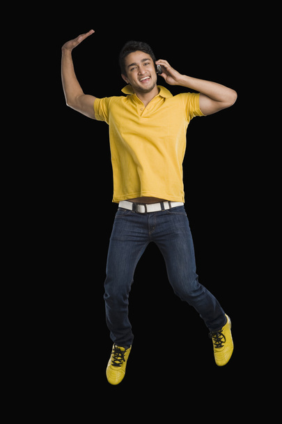 Hombre hablando en un teléfono móvil y saltando
 - Foto, Imagen