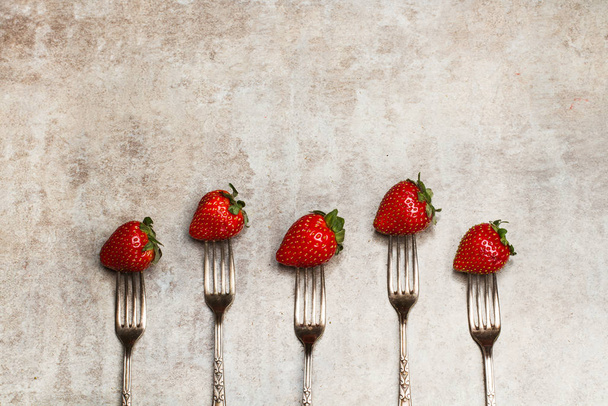 Aardbeien en vorken op een marmeren tafel - Foto, afbeelding