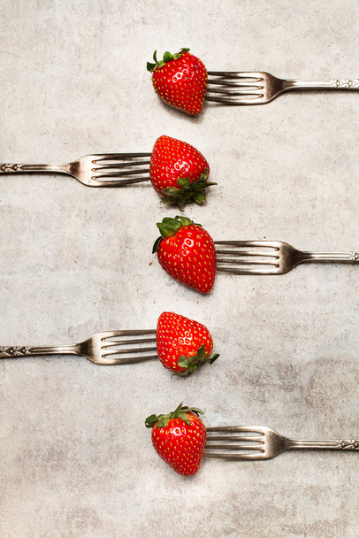 Fresas y tenedores sobre una mesa de mármol
 - Foto, Imagen