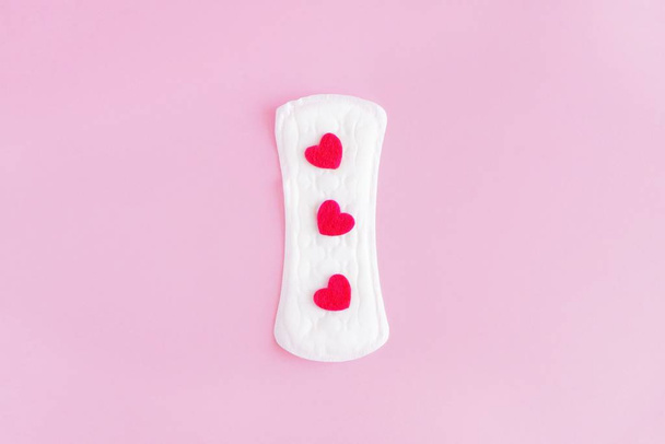 Sanitary pad on a pink background. An alternative choice of feminine hygiene products. Menstrual mothly cycle, means of protection. Top view, flat lay, copy space for text. - 写真・画像