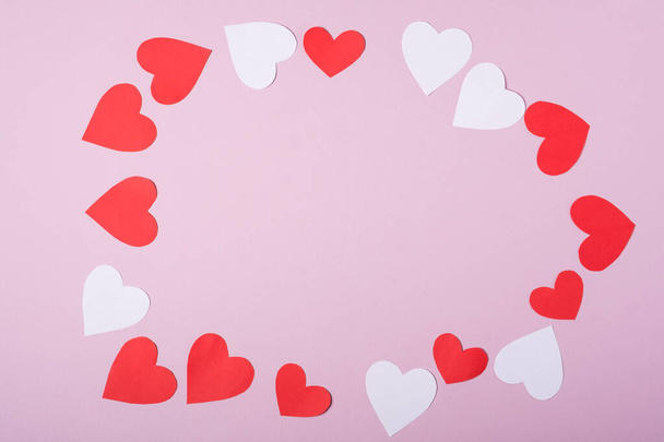 Červené a bílé ručně vyráběné papírové srdce valentinky rám na růžovém pozadí, kopírovací prostor, horní pohled - Fotografie, Obrázek
