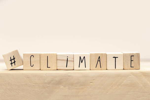 Wooden cubes with a Hashtag and the word Climate, social media and environment concept near white background - Photo, Image
