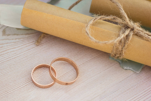 Detailní pohled na snubní prsteny a dva srolované papírové listy se svatebními sliby. - Fotografie, Obrázek