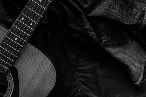 Acoustic guitar with a denim jacket, black and white. - Photo, Image