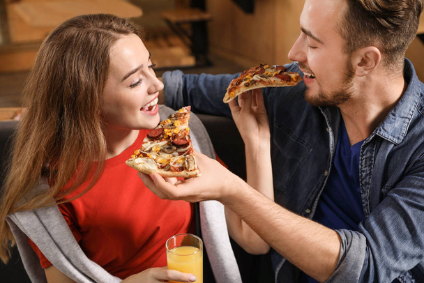 Jeune couple mangeant de délicieuses pizzas au café
 - Photo, image