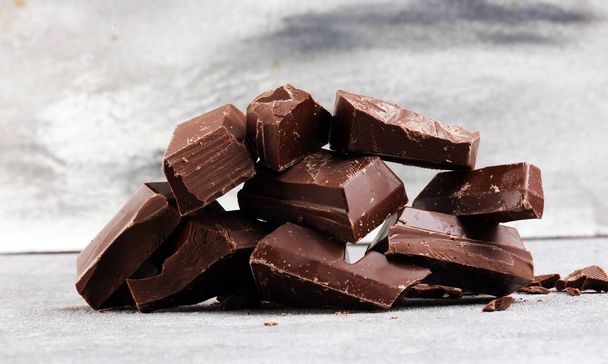Σκούρα στοίβα σοκολάτας, τσιπ και σκόνη με σοκολάτες και β - Φωτογραφία, εικόνα