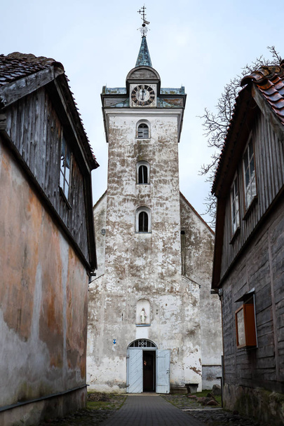 Old white countryside church with tower near small houses in old - Photo, Image