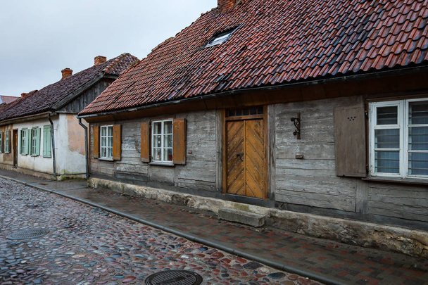 Casas antiguas cerca de camino de ladrillo y camino con exterior de madera
. - Foto, Imagen