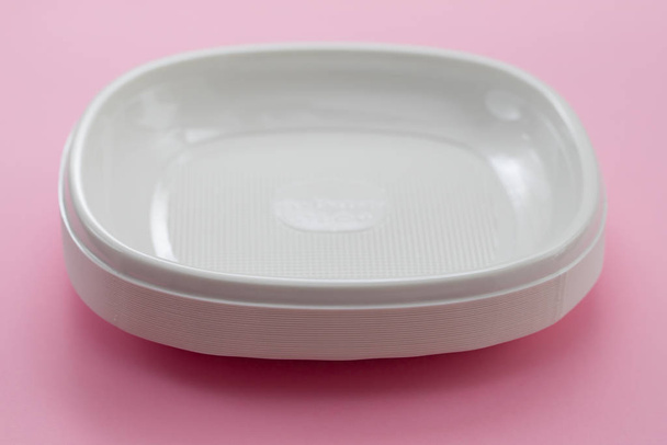 plastic plates on pink paper background - Photo, Image