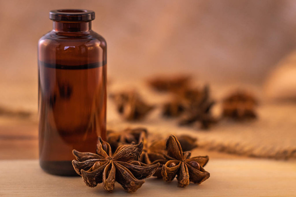 Anise essential oil in caramel colored bottle with anise seeds - Foto, afbeelding