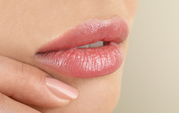 Woman with beautiful full lips on beige background, closeup - Foto, Imagem