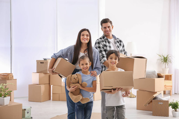 Happy family in room with cardboard boxes on moving day - Φωτογραφία, εικόνα