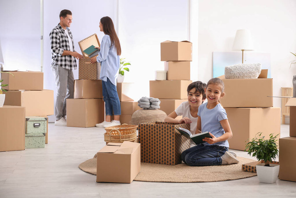 Happy family unpacking moving boxes at their new home - Valokuva, kuva