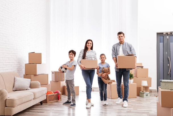 Счастливая семья в номере с картонными коробками в день переезда
 - Фото, изображение