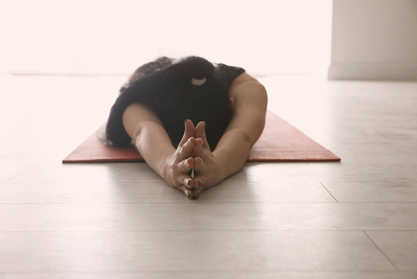 Young woman practicing relaxation pose in yoga studio, closeup - Foto, Imagem