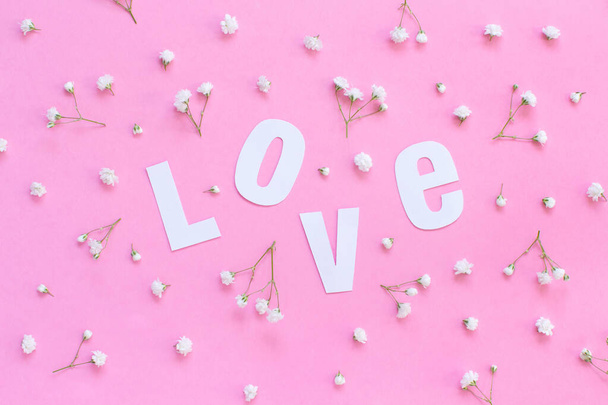 Virágok és szerelem felirat egy világos rózsaszín háttér - Fotó, kép