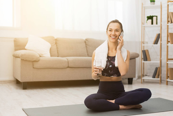Boldog nő beszél telefonon edzés után otthon - Fotó, kép