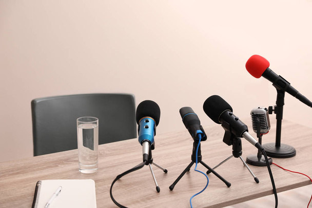 Journalist's microphones on wooden table in room - Zdjęcie, obraz